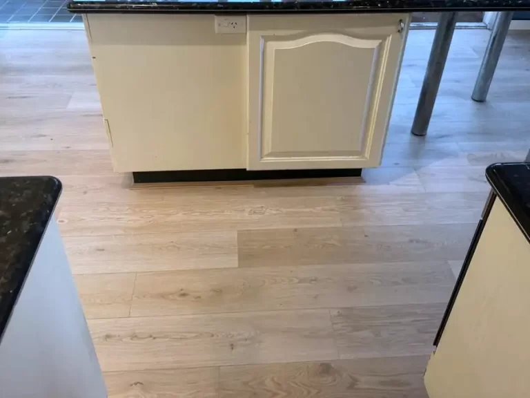 Light oak timber-look laminate flooring installed in a Sydney kitchen with a stone-top island bench