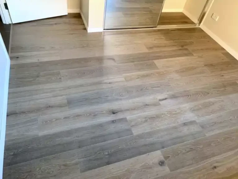 Grey oak-look plank flooring in a Sydney master bedroom with mirrored robe